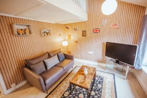 a living room with a couch and a flat screen tv at KENDAL HOLIDAY FLATS in Kendal