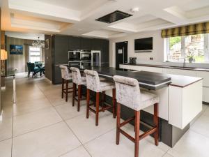 a kitchen with a black counter and bar stools at Glamorgan House in Cardiff