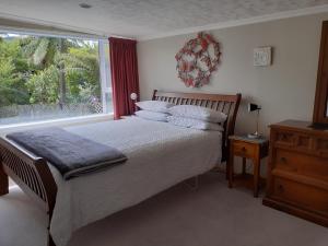 a bedroom with a bed and a large window at Mahakipawa Hideaway - Marlborough Sounds Home in Havelock