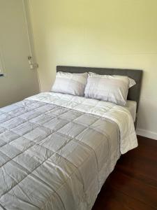 a bed with white sheets and pillows in a bedroom at มานาตาฟาร์มสเตย์ in Ban Thong Noi (1) +5 photos