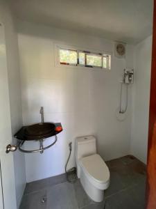 a small bathroom with a toilet and a sink at มานาตาฟาร์มสเตย์ in Ban Thong Noi (1)