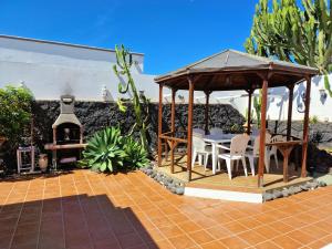 a gazebo with a table and chairs on a patio at Villa Lagarto heated pool aircon central Playa Blanca in Playa Blanca