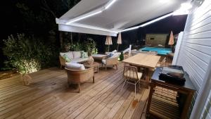 una terrazza con tavolo, sedie e piscina di Les Chalets du Golf de Biscarrosse a Biscarrosse