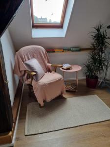 a chair with a blanket sitting in a room with a table at Haus Mali in Heiligenberg