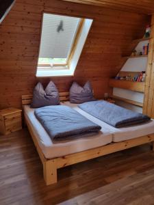 a bed in a wooden room with a window at Haus Mali in Heiligenberg