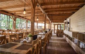 un restaurante con mesas de madera y sillas de madera en Cozy Home In Ruciane - Nida With Kitchen, en Ruciane-Nida