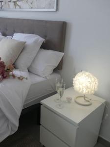 a bed with white pillows and a table with a lamp at 19 Piso céntrico, nuevo y bien equipado en La Trinidad in La Laguna