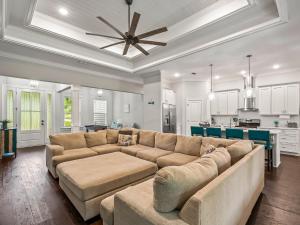 a living room with a large couch and a kitchen at Timber and Tides in Crawfordville