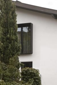 a white house with a window and a tree at Kaiserau-Höfl in Bolzano