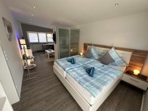 um quarto com uma cama grande e almofadas azuis em Auszeit Apartment Düsseldorf em Düsseldorf