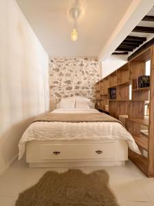 ein Schlafzimmer mit einem weißen Bett und einer Steinmauer in der Unterkunft Le balneo jacuzzi Vieil Antibes Safranier in Antibes