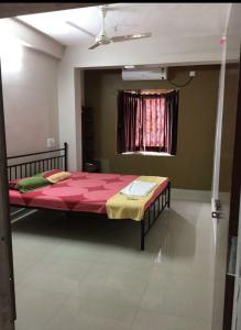 1 dormitorio con 1 cama grande de color rojo en una habitación en AR HOME STAY, en Chennai