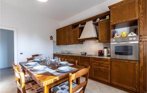 cocina con mesa de madera con sillas y microondas en Villa Sambuco, en San Gervasio