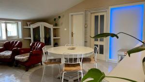 - un salon avec une table et des chaises blanches dans l'établissement Il Villino (Melfi), à Melfi