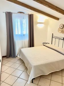 Schlafzimmer mit einem Bett und einem Fenster in der Unterkunft I trulli di Eva in Noci