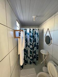 a bathroom with a shower curtain and a toilet at Dlux Suites Baia Formosa in Baía Formosa
