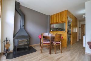 a dining room with a table and a wood stove at Apartamento La Ginesta 2 in Taüll