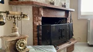 - une cheminée dans une pièce avec une table et une lampe dans l'établissement Il Villino (Melfi), à Melfi