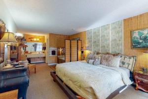 a bedroom with a large bed and a living room at Jacuzzi Suite 205 at Tradewinds in Eureka Springs