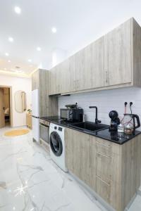 a kitchen with a sink and a washing machine at Zeos finest jacuzzi Suite in Athens