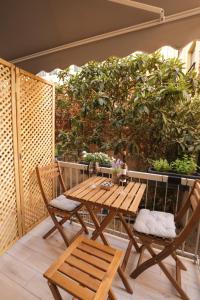 una mesa de madera y 2 sillas en el patio en Zeos finest jacuzzi Suite, en Atenas