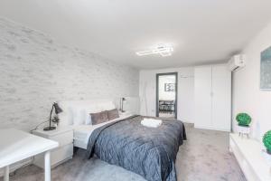 1 dormitorio con cama y pared blanca en Deluxe Quentin Apartment next to the Heroes Square, en Budapest