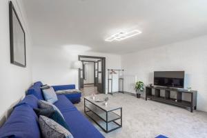 a living room with a blue couch and a tv at Deluxe Quentin Apartment next to the Heroes Square in Budapest