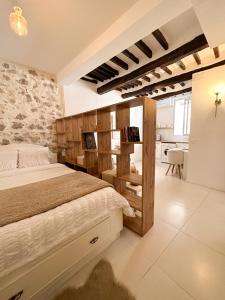 a bedroom with a bed and a stone wall at Le balneo jacuzzi Vieil Antibes Safranier in Antibes