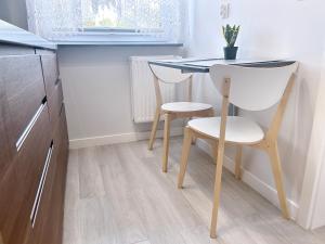 a small kitchen with a table and a chair at Apartament Neon in Szczecin