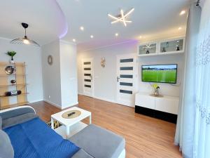 a living room with a couch and a flat screen tv at Apartament Neon in Szczecin