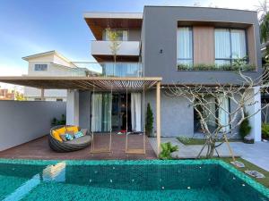 a house with a tire next to a swimming pool at Song Cat villa - 49DP8 in Danang