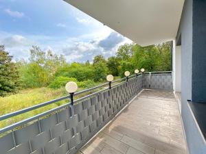 a balcony with a view of the woods at Apartament Neon in Szczecin +7 photos