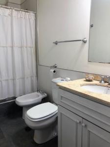 a bathroom with a toilet and a sink and a mirror at Departamento de Noah in Guaymallen