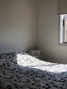 - une chambre avec un lit et une couverture noire et blanche dans l'établissement Departamento de Noah, à Guaymallen