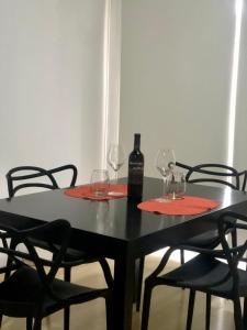 - une table noire avec 2 verres et une bouteille de vin dans l'établissement Departamento de Noah, à Guaymallen