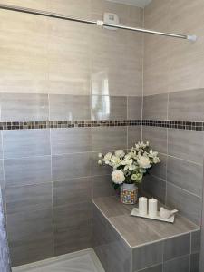 a bathroom with a vase of flowers and candles at La belle Charentaise in Vaux-Rouillac +6 photos