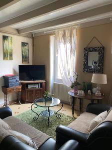 a living room with a couch and a television at La belle Charentaise 