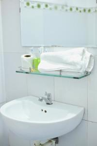 a bathroom with a sink and a shelf with towels at Shine Riverside Homestay in Hue