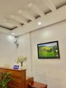 Habitación con TV en la pared en Shine Riverside Homestay, en Hue