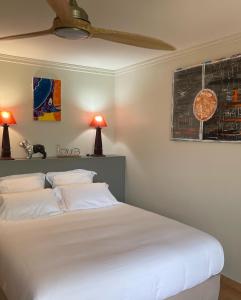 Un dormitorio con una cama blanca con dos almohadas blancas. en Bois Lélé, en Sainte-Anne