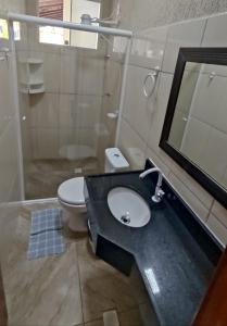 uma casa de banho com um lavatório, um WC e um espelho. em Recanto Primavera Ubatuba em Ubatuba