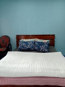 ein Bett mit einer weißen Bettdecke und einer blauen Wand in der Unterkunft Homestay Subarda Kamar Natural in Solok