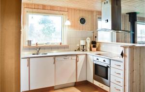 cocina con armarios blancos, fregadero y ventana en Cozy Home In Vinderup With Kitchen en Vinderup