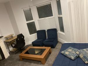 - un salon avec un canapé, deux chaises et une table dans l'établissement En-suite room near, à Cardiff