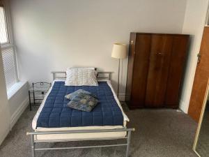 una camera con un letto e una coperta blu di En-suite room near a Cardiff