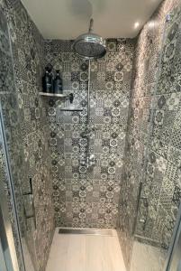 フィレンツェにあるCasa Margheritaのタイル張りの壁のバスルーム(シャワー付)