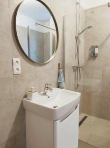 La salle de bains est pourvue d'un lavabo et d'un miroir. dans l'établissement Apartment Phoenix, à Štôla