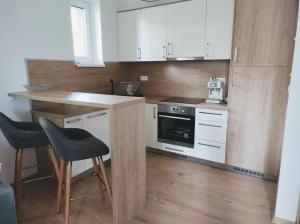 a kitchen with white cabinets and a table and chairs at Apartment Phoenix in Vyšné Hágy