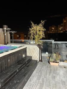 a wooden bench sitting on a patio at night at Suite 24/7-סוויטת 24/7 in Ramat Gan
