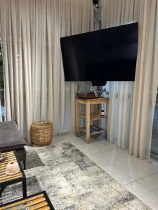 a large flat screen tv in a living room at Suite 24/7-סוויטת 24/7 in Ramat Gan